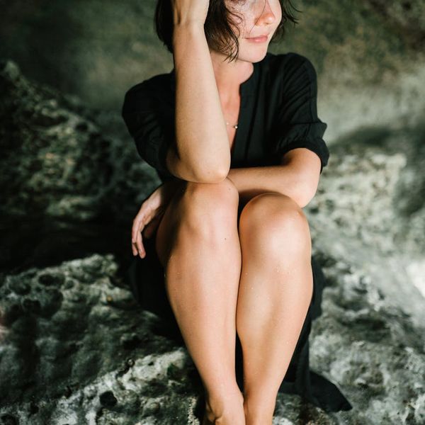 A person sitting in a meditative pose with a serene background.